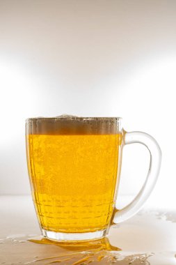 Bir bardak dolusu taze, hafif bira ve kalın köpük. Hafif biralı, köpüklü ve arkadan ışıklandırmalı bir kupa..