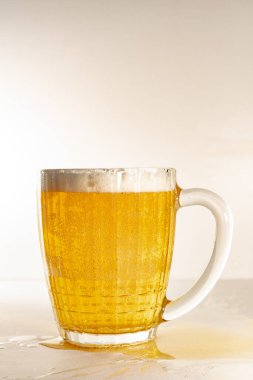 Cam bardak taze, hafif birayla dolu, kalın köpüklü. Bira bardağı ve köpüklü, hafif arka planlı..