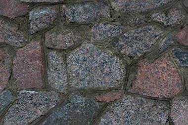 Kalıplı taş bir duvarın bir parçası. Güzel bir yaban taşı dokusu var. Eski kalenin duvarlarının bir parçasıydı. Çimento harcıyla bağlanmış vahşi taş..