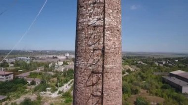 İnsansız hava aracının görüntüsü. Fabrika borusundan aşağı inin. Arka plandaki fabrikaların kalıntıları.