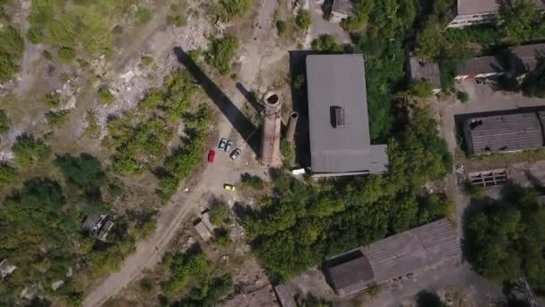 Uitzicht vanaf de drone. Vertrek uit de fabrieksschoorsteen. Ruïnes van fabrieken op de achtergrond. — Stockvideo
