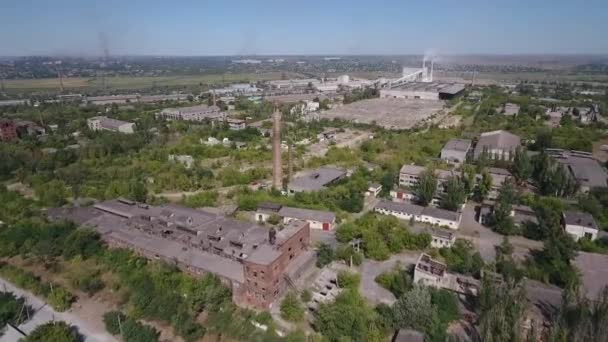 Uitzicht vanaf de drone. Ruïnes van fabrieken en een oude fabrieksschoorsteen — Stockvideo