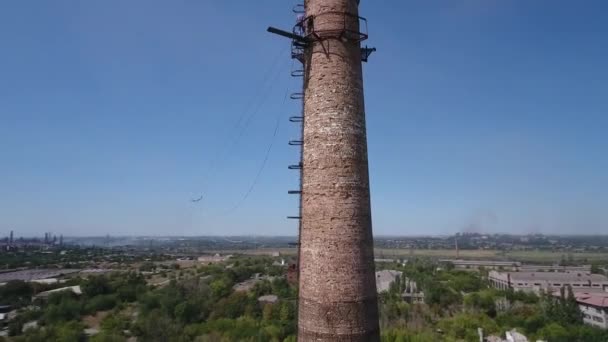 Vista desde el dron. Rodeando la antigua chimenea de la fábrica. Ruinas de fábricas en el fondo. — Vídeos de Stock