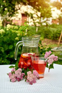 Çilekli meyve suyu ve masada ayçöreği olan limon. Farklı turunçgillerden ev yapımı limonata. Bahçe arka planında ferahlatıcı yaz içeceği.
