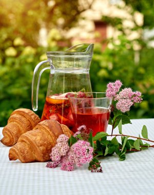 Çilekli meyve suyu ve masada ayçöreği olan limon. Farklı turunçgillerden ev yapımı limonata. Bahçe arka planında ferahlatıcı yaz içeceği.