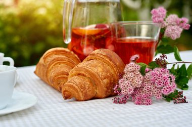 Çilekli meyve suyu ve masada ayçöreği olan limon. Farklı turunçgillerden ev yapımı limonata. Bahçe arka planında ferahlatıcı yaz içeceği.