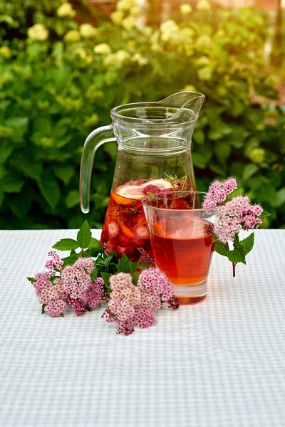 Çilekli meyve suyu ve masada ayçöreği olan limon. Farklı turunçgillerden ev yapımı limonata. Bahçe arka planında ferahlatıcı yaz içeceği.
