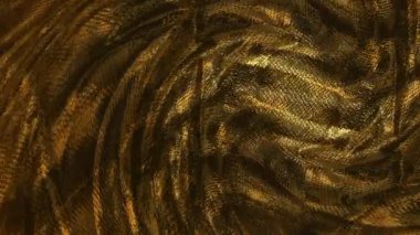 Altın kıvrımlı ve kıvrımlı şekil dokuları büküldükçe yavaşça hareket eder..