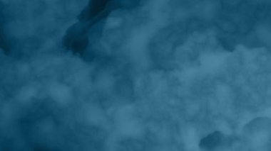Koyu bir arkaplanda yükselen mavi duman.