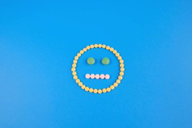 Sarı, beyaz ve yeşil haplardan yayılmış simgeler