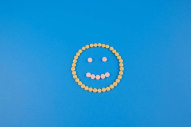 Sarı ve beyaz haplar yüzünden gülen surat