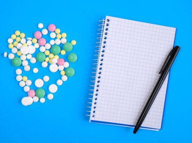 Metin için boş alan. Hapların arasında kalem olan defter. reçete