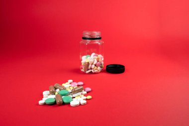 Kırmızı arka planda sağlık için ilaç içeren plastik bir şişe. Kimya ve İlaç Bilimi.