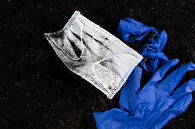 Tıbbi maske ve yerde mavi tıbbi eldiven. Metin için boş alan ve boşluk. Ekolojik sorunlar. Çevre kirliliği