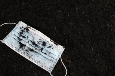 Kullanılmış, eski bir tıbbi yüz maskesi. Metin için boş alan ve boşluk. Ekolojik sorunlar. Çevre kirliliği