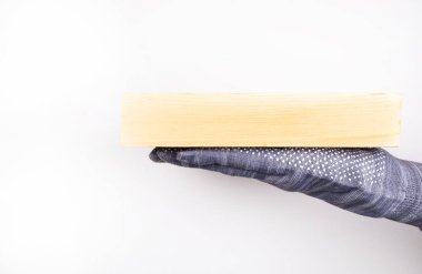 Ahşap blok palmiye üzerinde duruyor. Eldiven verin. Ağaç tartıyorum. Bir apartman dairesinde, evde tamirat. İnşaat.