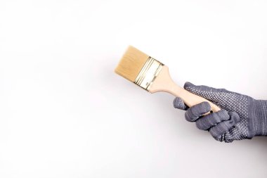 Eldivenli bir el boya fırçası tutar. İnsan duvarları boyar.