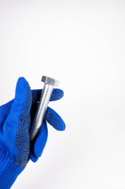 Beyaz arka planda büyük bir cıvata var. Eldivendeki bir el bir aleti tutar.