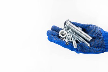 Vidalar, somunlar, beyaz arka planda avucunun içinde vidalar. Mavi eldivenli bir el avuç içini açar. El araçları gösterir