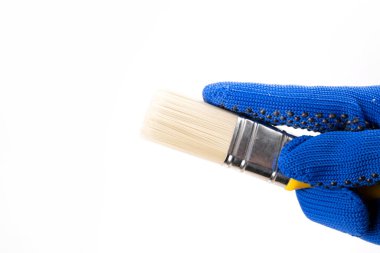 Beyaz arkaplanda sarı boya fırçası olan el.