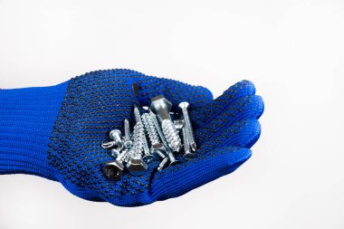 İnşaat malzemeleri. Kendi kendine dokunan vidalar. Bir inşaat eldiveni kendi kendine dokunabilen vidaları tutar.