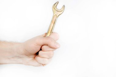 Beyaz arka planda büyük bir anahtar. İngiliz anahtarı tutan bir adam, boş yer.