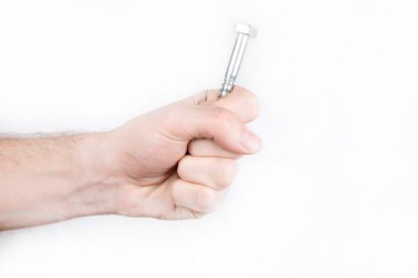 Beyaz arka planda kendini beceren bir sürü vida var. Bir adamın eli kendini beceren vidaları tutar.