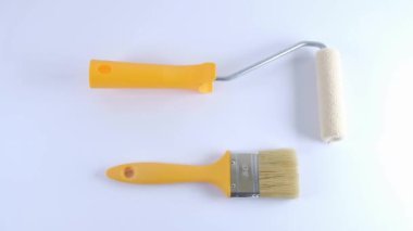 Beyaz arka planda fırça seti. Bir erkek bir araç seçer. Parmaklar elleri gösteriyor.