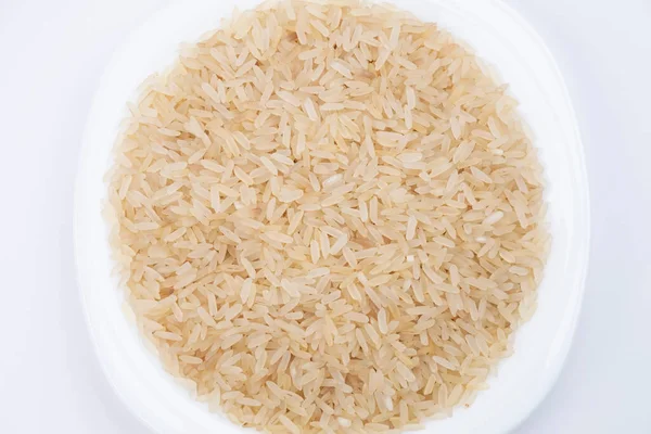 米在白色背景的特写 米饭在白盘里 把米饭放在盘子里 选择煮饭用的米饭 健康食品 — 图库照片