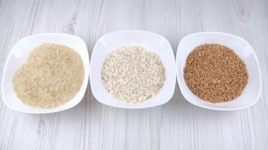 pirinç karabuğdaylı yulaf ezmesi. Bir kadının eli mısır gevreği tabağını alır. Sağlıklı gıda seçimi. Diyet yemek. Karbonhidratlar. diyet tarifleri