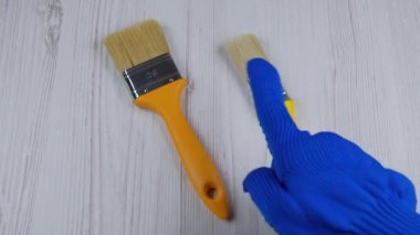 Fırçalar masanın üzerinde duruyor. Parmak eli işaret ediyor. Fırça seçimi