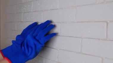 El fırçaları tutar. Parmak fırçayı gösteriyor. Onarım aracı seçimi