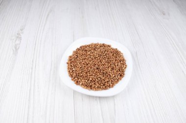 Masadaki beyaz tabakta karabuğday. Mutfakta karabuğday