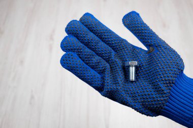 Elinde metal cıvata var. Avucunun içinde metal bir cıvata var. Araç boyutu