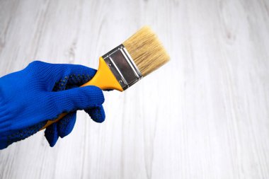 Elinde büyük temiz boya fırçası var.