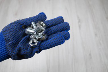 Cıvatalar ve dişiler el ele tutuşur. Eldiven tutan civata ve dişi vida