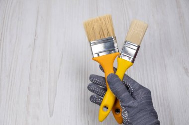 Boya fırçaları elinde. Fırçaların haç sembolü.