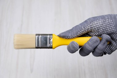 Elinde küçük temiz bir boya fırçası var. Onarım için araçlar