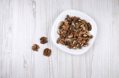 Beyaz tabakta ceviz. Masadaki ceviz çekirdekleri. Sağlıklı yemek.