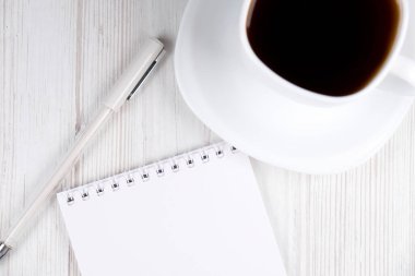 Ofis masası. Kahve, defter ve kalem tahtada, yakın plan.