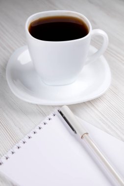 Ofis masası. Kahve, defter ve kalem tahtada, yakın plan.