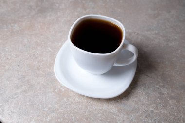 Taş bir masanın üzerinde bir fincan kahve. Sabah için iç.