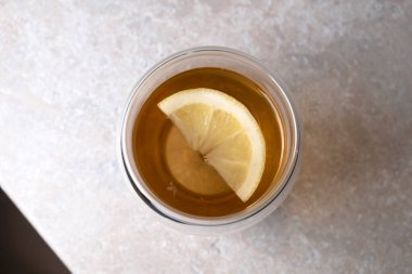 Mutfak masasındaki cam bardakta limonlu çay.