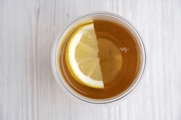 Tahta bir masada, cam bardakta limonlu çay, boş yer, üst manzara sağlıklı içecek. Ilık içecek.