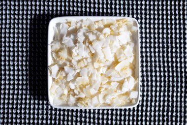 Damalı havluyla beyaz tabakta hindistan cevizi yaprakları.