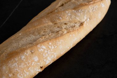 Siyah arkaplanda beyaz ekmek, yakın plan.