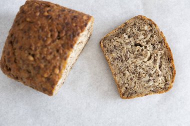 Tohumlu ekmek ve beyaz arka planda bir parça ekmek, yakın plan.