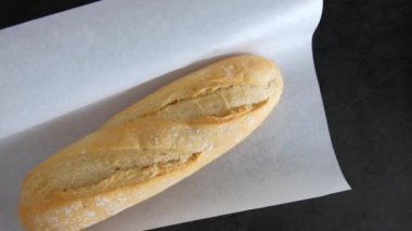 Kağıt üzerinde beyaz ekmek. Parşömen taze ekmek için açılıyor..