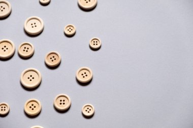 many buttons. Many buttons of different sizes on a gray background, free space. Sewing materials. Sewing