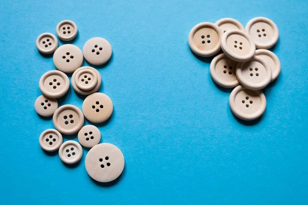 Various buttons. Wooden buttons on a blue background. Sewing. Place for text.